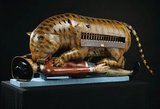 Tipu's Tiger belonged to Tipu Sultan, ruler of Mysore (1782-1799). The almost life-size wooden automaton represents a tiger mauling a prostrate figure in European clothes. There is an organ inside the tiger's body. When a handle is turned, the organ plays and the victim's arm rises and falls.<br/><br/>

The tiger was taken by the British from the palace at Mysorel after the Siege of Seringapatam in 1799. It was sent to the headquarters of the East India Company in London where it was exhibited. It was later transferred to the Victoria and Albert Museum in South Kensingtion.
